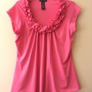 Pink top with ruffles outlining scoop neck
